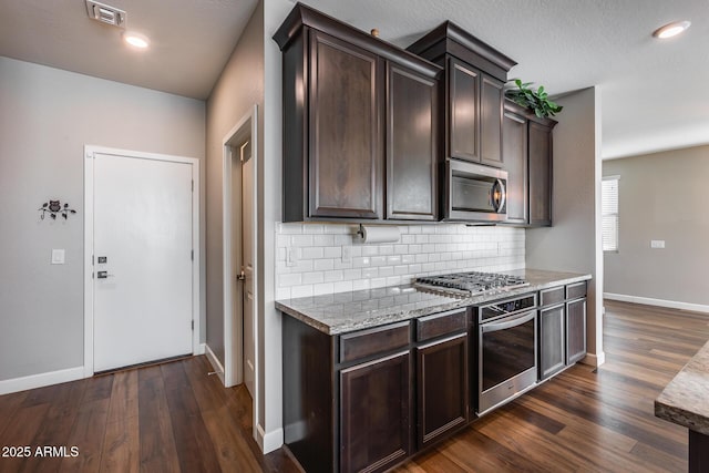 kitchen featuring dark brown cabinets, stainless steel appliances, and dark hardwood / wood-style floors