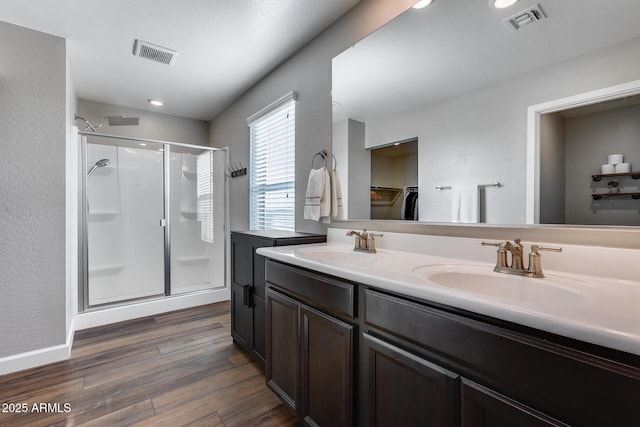 bathroom with hardwood / wood-style flooring, vanity, and a shower with door