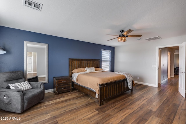 bedroom with a textured ceiling, ceiling fan, and dark wood-type flooring