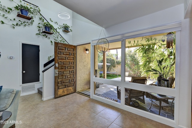 interior space featuring high vaulted ceiling and tile patterned floors