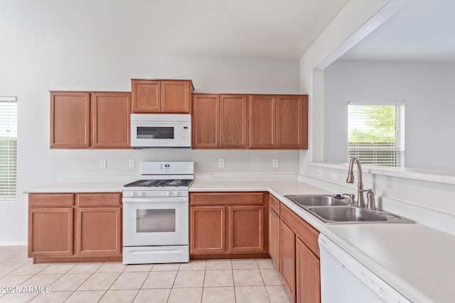 kitchen featuring light tile patterned flooring, white appliances, and sink