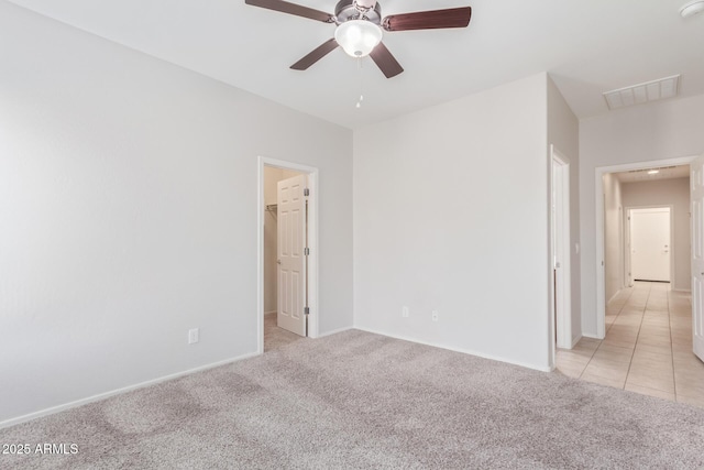 carpeted spare room featuring ceiling fan