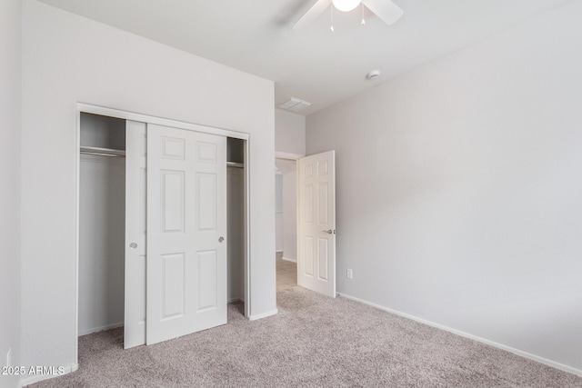 unfurnished bedroom featuring light colored carpet, a closet, and ceiling fan