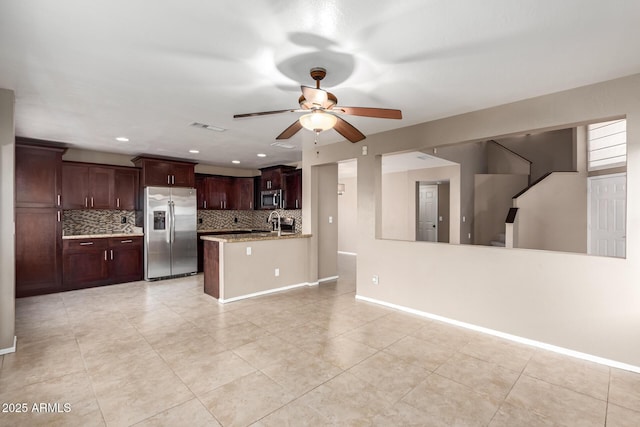 kitchen with light stone counters, backsplash, appliances with stainless steel finishes, ceiling fan, and dark brown cabinetry