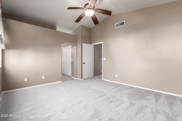 carpeted spare room featuring ceiling fan and high vaulted ceiling