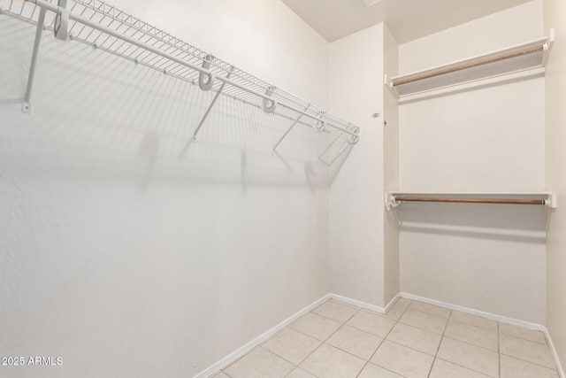 spacious closet with light tile patterned floors