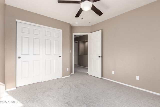 unfurnished bedroom with a closet, ceiling fan, and light colored carpet