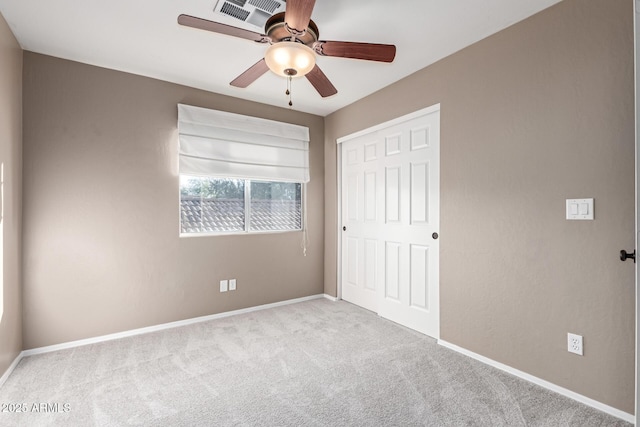 unfurnished bedroom featuring ceiling fan, a closet, and light carpet