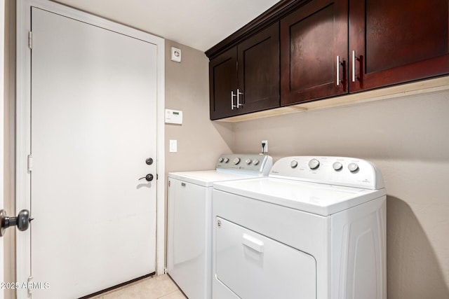 laundry room with light tile patterned floors, cabinets, and independent washer and dryer