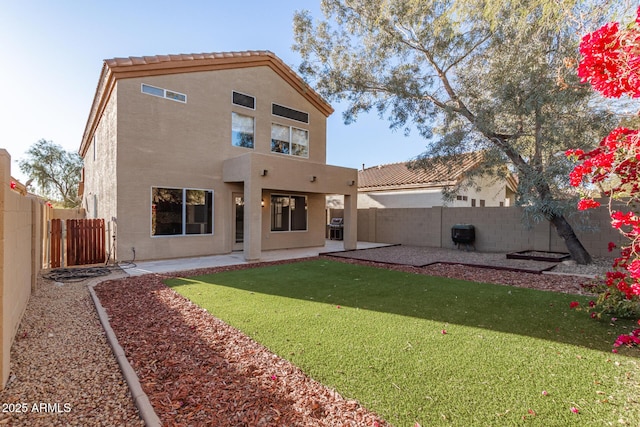 rear view of property featuring a lawn and a patio area