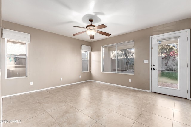 tiled empty room featuring ceiling fan