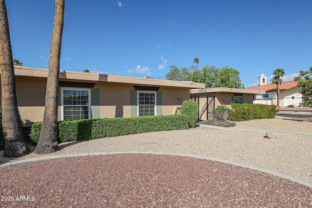 ranch-style house featuring stucco siding