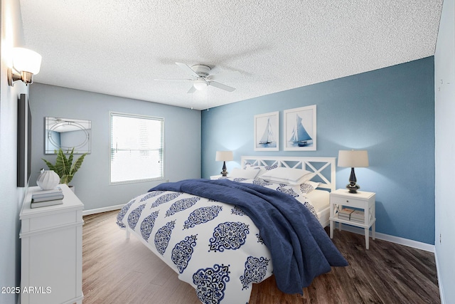 bedroom featuring baseboards, a ceiling fan, wood finished floors, and a textured ceiling