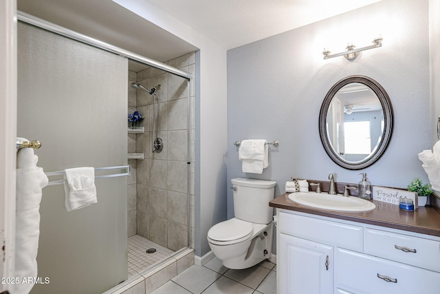full bathroom featuring toilet, vanity, tile patterned flooring, and a tile shower