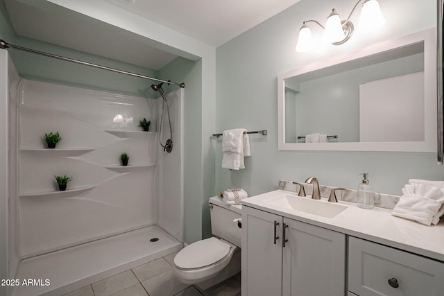 bathroom featuring vanity, tile patterned flooring, a shower, and toilet