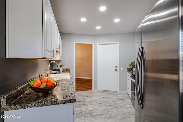 kitchen featuring a sink, stainless steel appliances, light wood-style flooring, white cabinetry, and recessed lighting