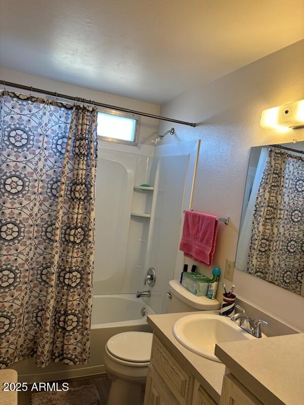 full bathroom featuring vanity, shower / bath combination with curtain, and toilet