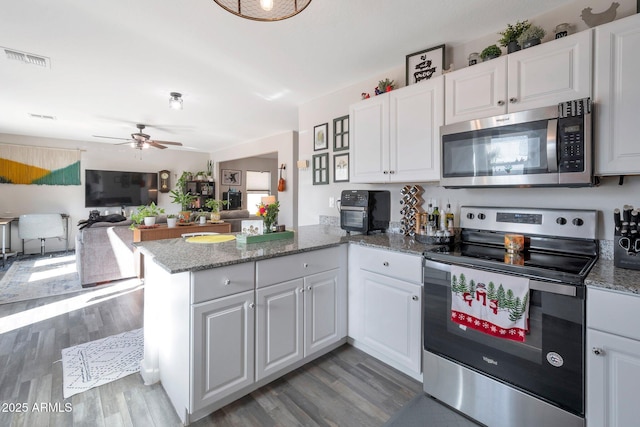 kitchen with kitchen peninsula, white cabinets, and stainless steel appliances