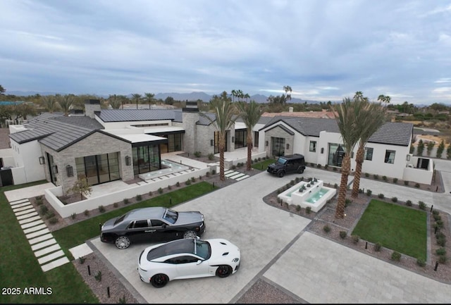 exterior space with a patio area, stone siding, a residential view, and a hot tub
