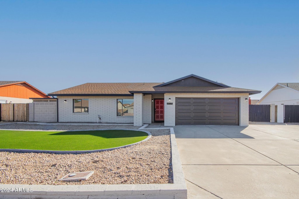 ranch-style home featuring a garage and a front yard