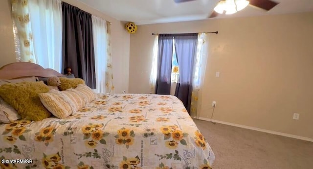 carpeted bedroom with a ceiling fan and baseboards