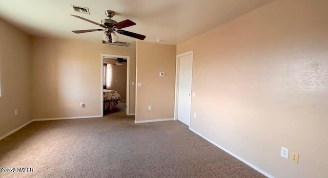 interior space with a ceiling fan, baseboards, visible vents, and carpet floors