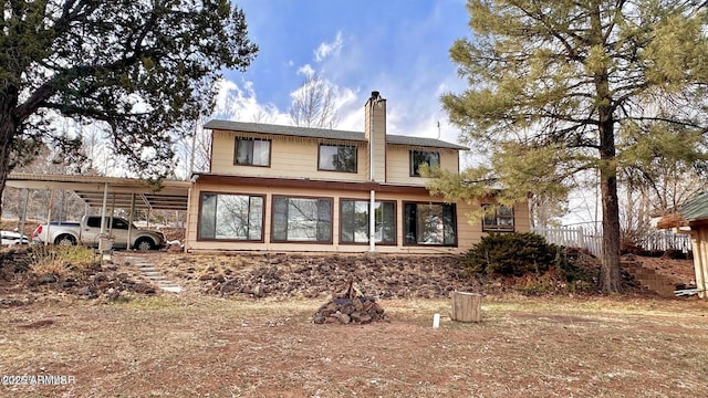 back of property featuring a carport and a chimney