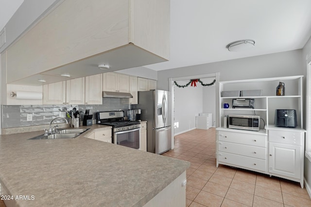 kitchen with decorative backsplash, appliances with stainless steel finishes, sink, light tile patterned floors, and white cabinets