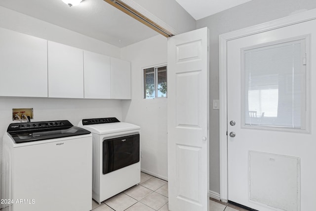 laundry area with cabinets, light tile patterned floors, and washing machine and clothes dryer