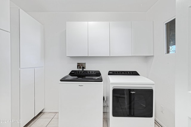 washroom with cabinets, light tile patterned floors, and separate washer and dryer