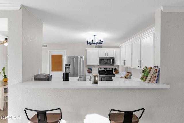 kitchen with kitchen peninsula, appliances with stainless steel finishes, a breakfast bar, light hardwood / wood-style flooring, and white cabinets