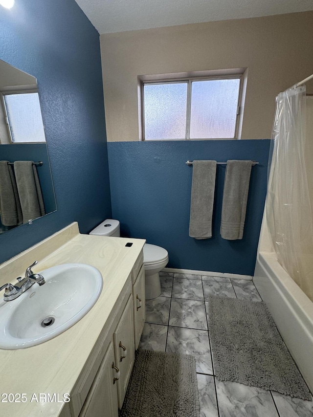 bathroom featuring toilet, marble finish floor, vanity, baseboards, and shower / tub combo