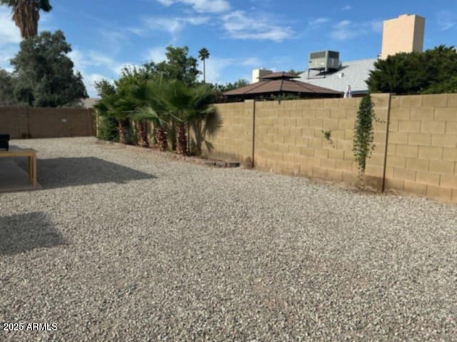 view of yard featuring a fenced backyard and central AC