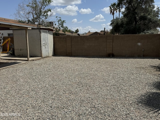 view of yard featuring an outbuilding, fence, and a storage unit