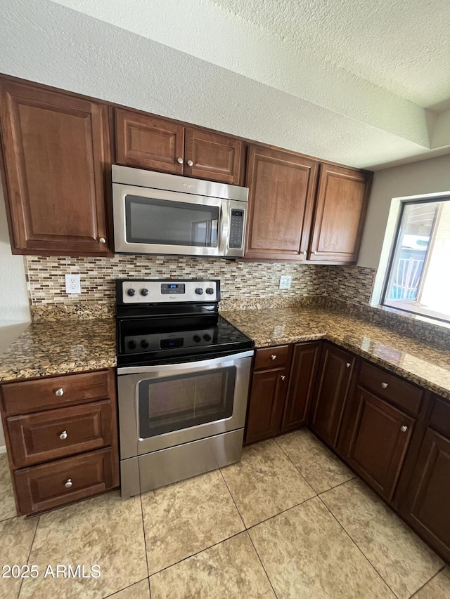 662 W Laguna Azul Ave, Mesa, AZ 85210 - kitchen with appliances with stainless steel finishes, decorative backsplash, dark stone countertops, a textured ceiling, and light tile patterned floors