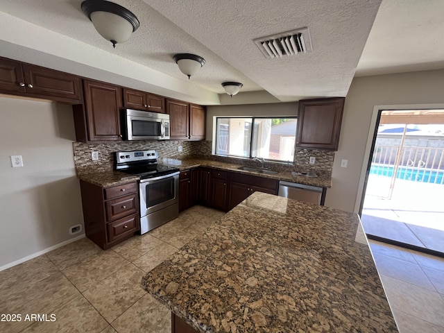 662 W Laguna Azul Ave, Mesa, AZ 85210 - kitchen featuring stainless steel appliances, decorative backsplash, healthy amount of natural light, light tile patterned floors, and a textured ceiling