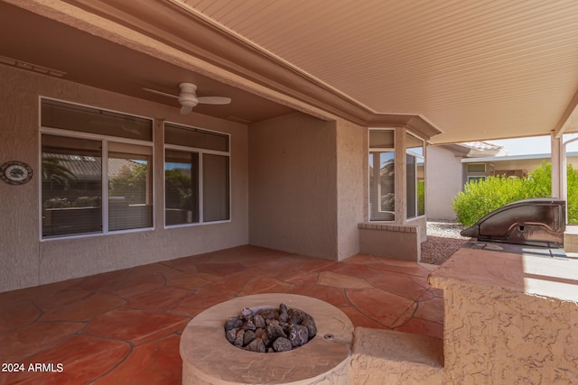 view of patio with area for grilling, ceiling fan, and a fire pit