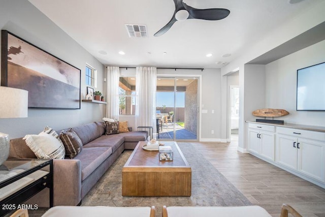 12239 W Caraveo Pl, Peoria, AZ 85383 - living room with light wood finished floors, a ceiling fan, healthy amount of natural light, recessed lighting, and baseboards