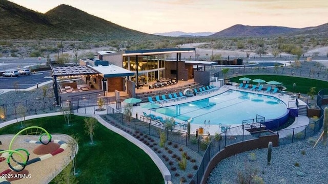 12239 W Caraveo Pl, Peoria, AZ 85383 - community pool with a mountain view, fence, and a patio area