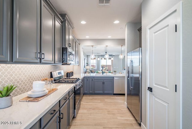 12239 W Caraveo Pl, Peoria, AZ 85383 - kitchen with appliances with stainless steel finishes, gray cabinetry, light countertops, decorative backsplash, and recessed lighting
