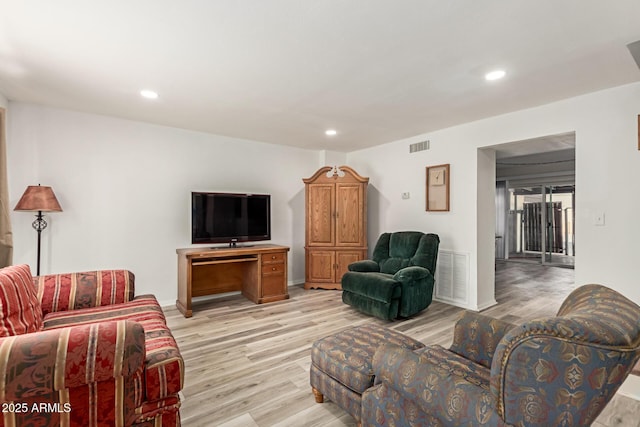 living room featuring light wood-type flooring, baseboards, visible vents, and recessed lighting