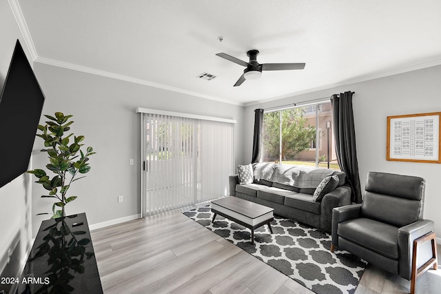 living room featuring visible vents, ornamental molding, a ceiling fan, wood finished floors, and baseboards