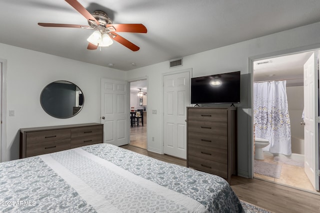 bedroom featuring ensuite bath, ceiling fan, and wood-type flooring