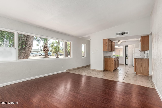 725 S Power Rd Unit 101, Mesa, AZ 85206 - unfurnished living room with light wood-style flooring, lofted ceiling, and a ceiling fan