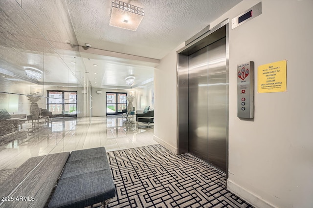 hall with elevator and a textured ceiling