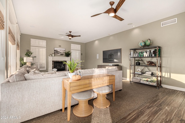 living room featuring ceiling fan and dark hardwood / wood-style flooring