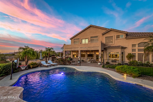 pool at dusk featuring a patio