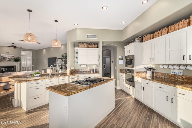 kitchen with a center island, hanging light fixtures, kitchen peninsula, and appliances with stainless steel finishes