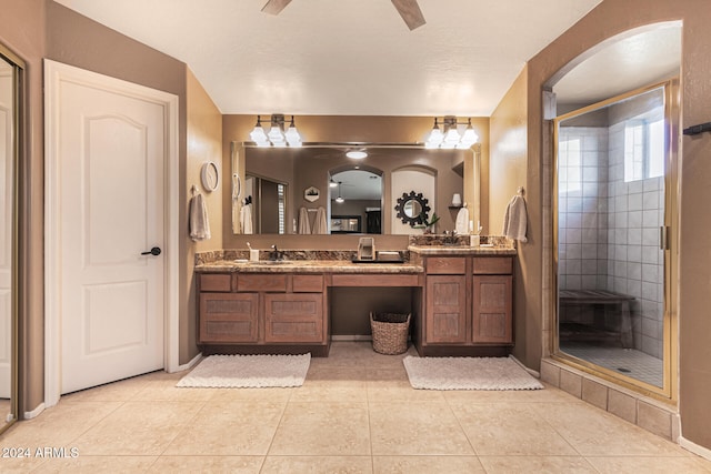 bathroom with a shower with door, tile patterned flooring, and vanity