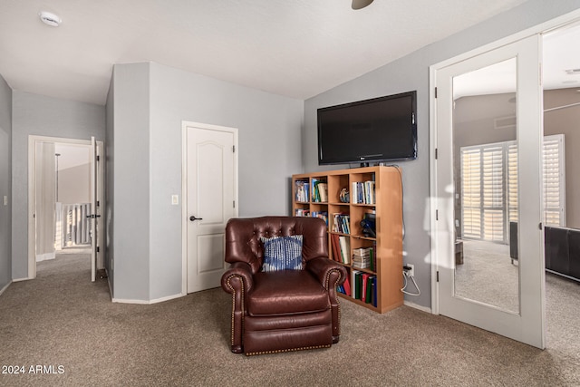 sitting room featuring lofted ceiling and carpet flooring